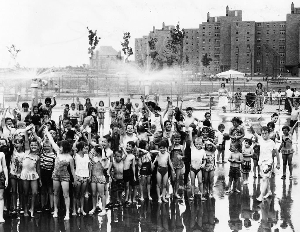 #69 Children play in the spray pool at the Columbia Point housing project in Boston on June 30, 1960.