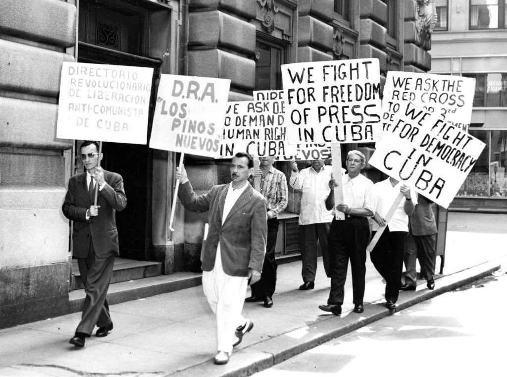 #72 Demonstrators hold signs while marching in front of the Cuban consulate in Boston in protest of Cuban Prime Minister FIdel Castro on June 5, 1960.