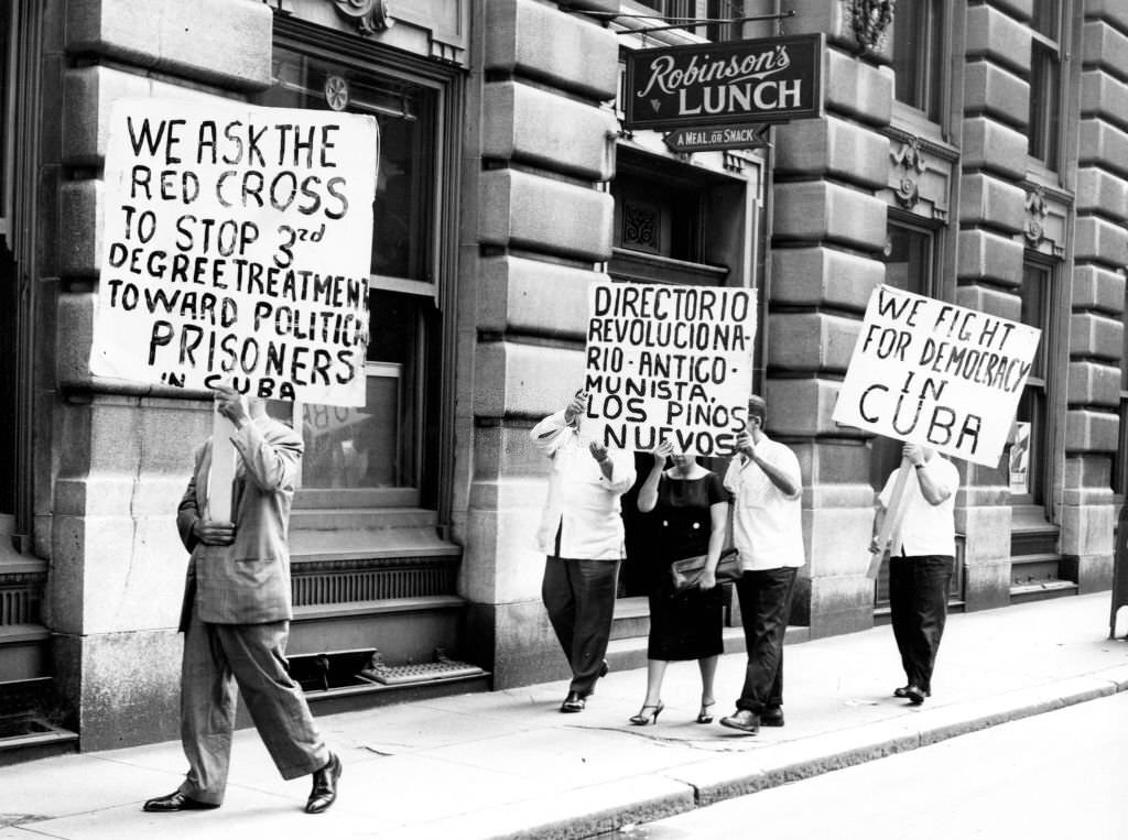 #73 Demonstrators hold signs while marching in front of the Cuban consulate in Boston in protest of Cuban Prime Minister Fidel Castro on June 5, 1960.