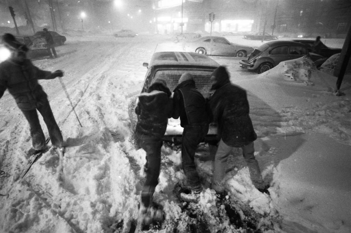 #16 Three people pushed a disabled car as a skier passed on Kelton Street near Commonwealth Avenue in Boston.