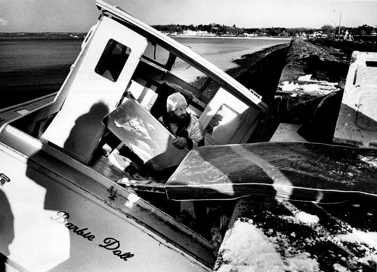 #32 A crew member unloaded a lost boat in Marblehead Harbor that washed up on the Causeway.