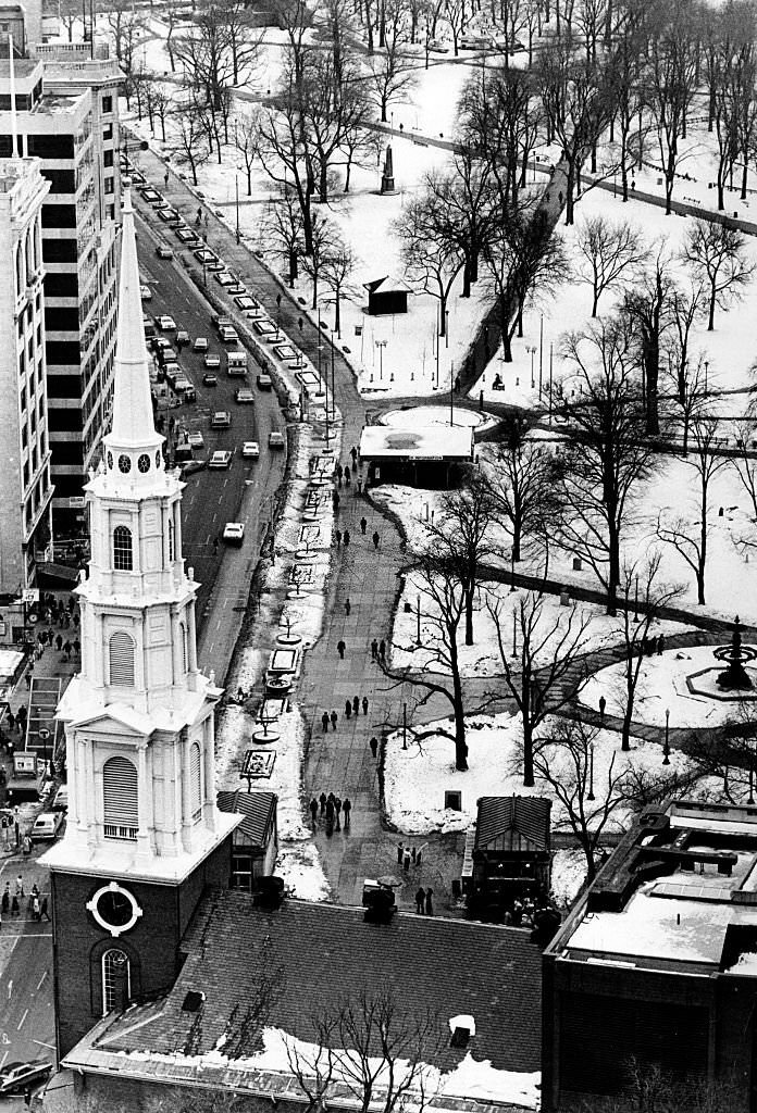 #120 The view from the 24th floor of One Beacon St. in Boston looks out over a the steeple and roof of the Park Street Church, Tremont Street and snowy Boston Common, 1977.