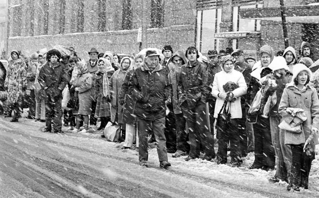 #137 Commuters wait for the bus in the snow at South Station in Boston, 1975.