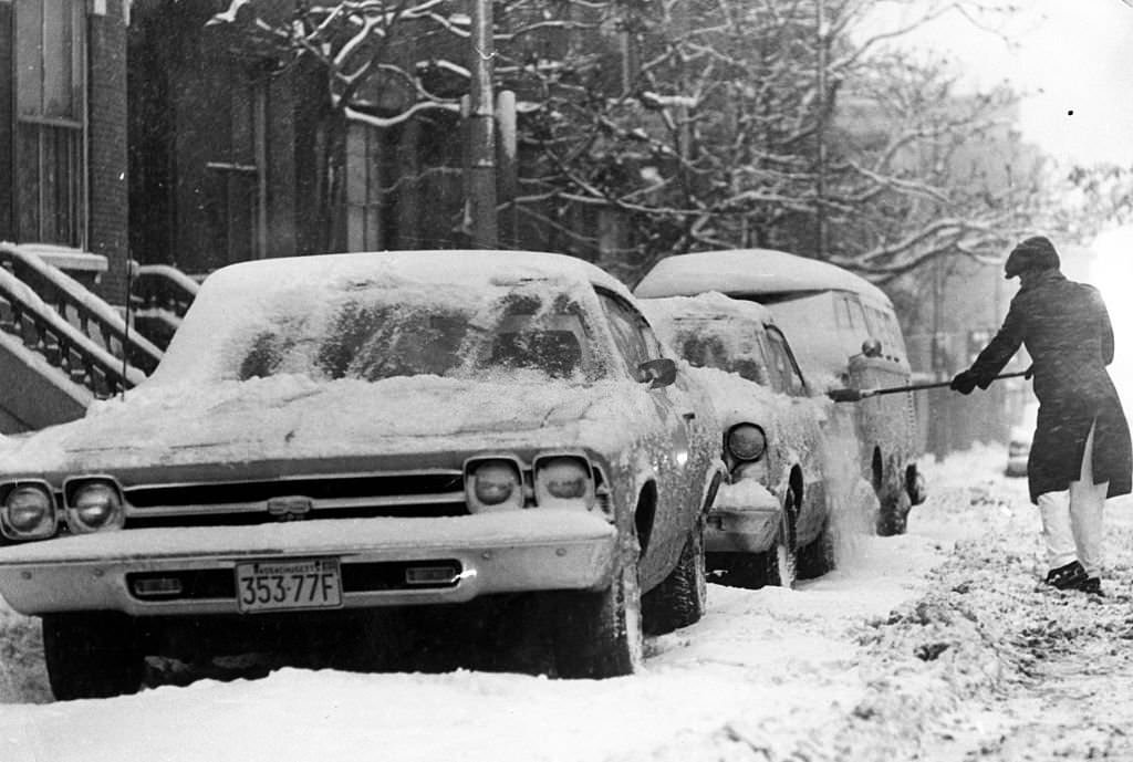 #150 Resident Willie Samuel brushes snow off a car on Massachusetts Avenue in Boston, 1971.