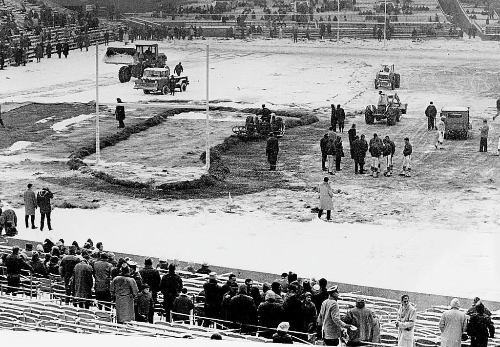 #44 Players and officials checked the field, which was being cleared of snow before the game at Fenway Park.