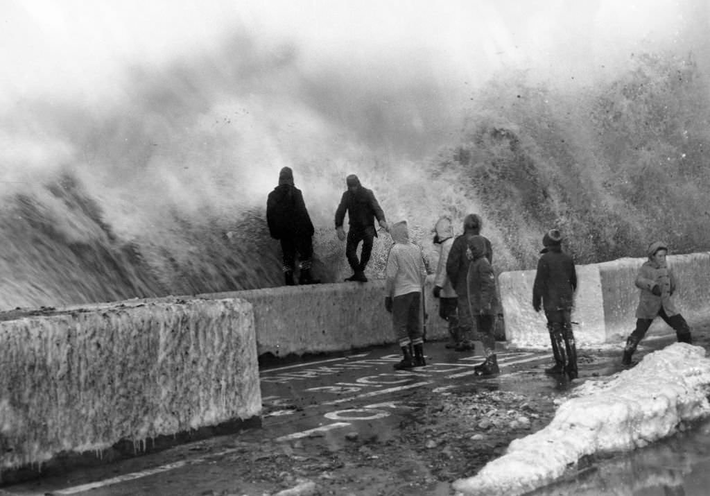 #53 Young residents along the Winthrop, Mass., shore drive play hazardous game with violent waves during a storm, 1961.