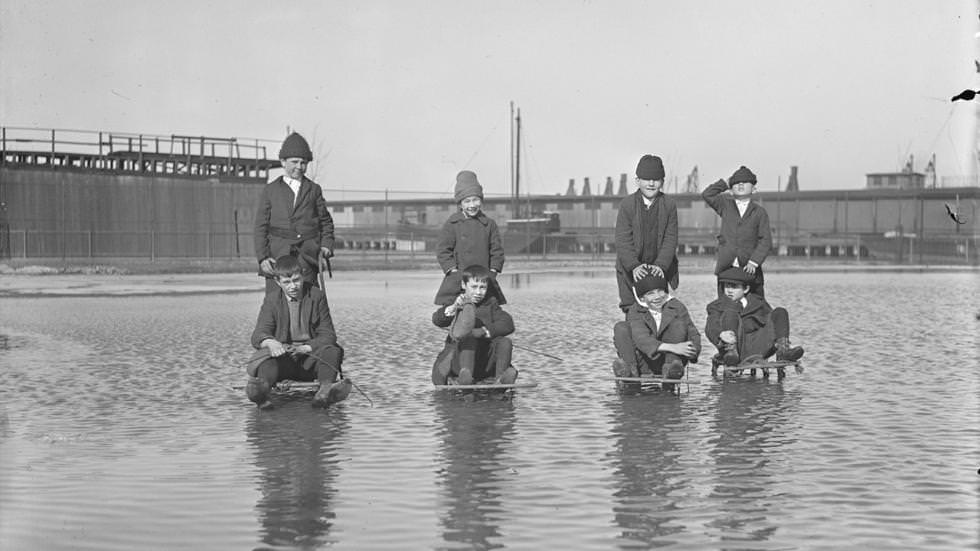 #10 Kids on sleds plough through water to enjoy ice hidden below, 1921