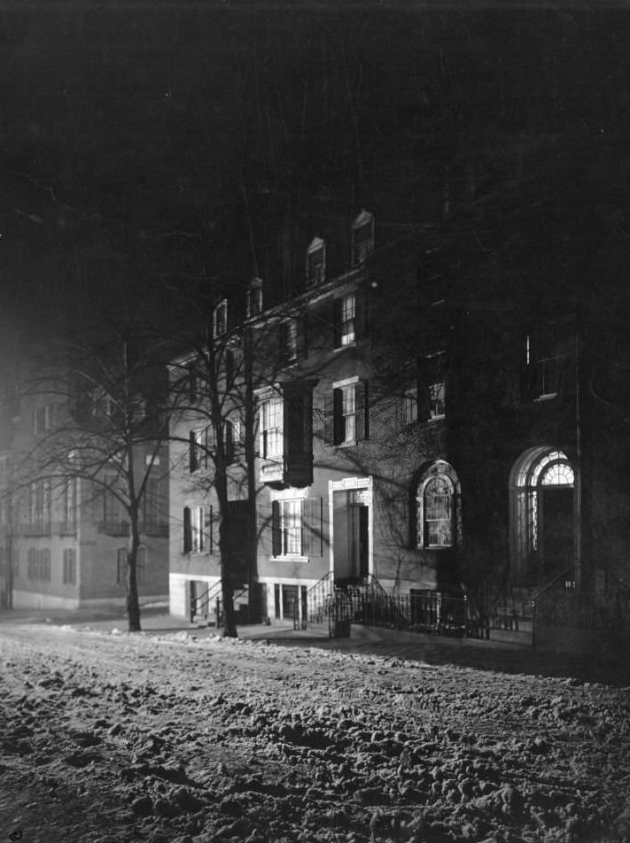 #98 Night winter view of snowy Chestnut Street, a few rowhouses lit from within, Boston, Massachusetts, 1906.