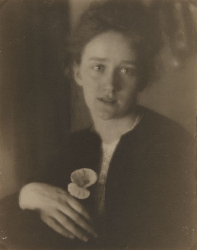 #22 Portrait of a woman holding flower, 1900