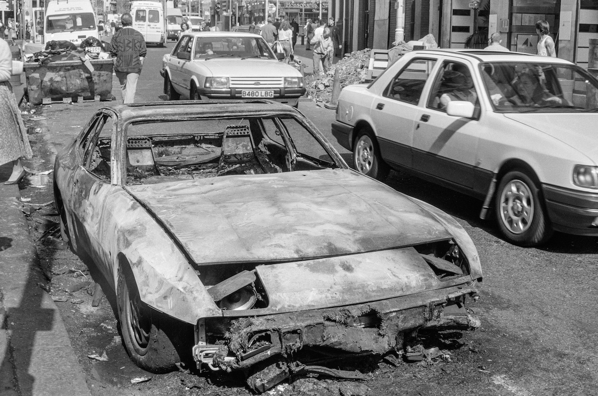 #19 Burnt out car, St Martin’s Lane, Covent Garden, Westminster, 1990