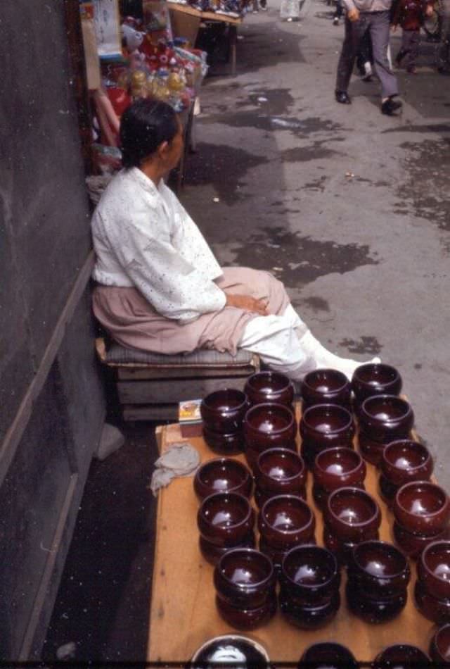 #20 Woman selling ceramic bowls, Tague, 1970s