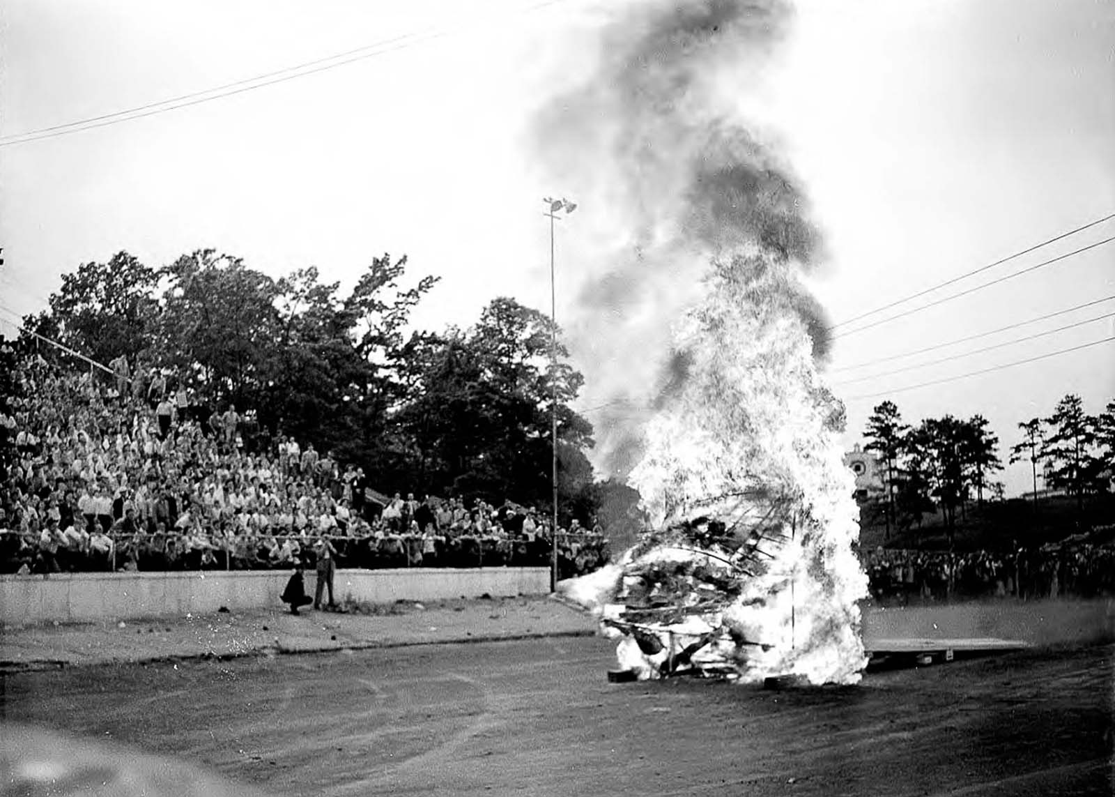 A Death Dodger drives a car through a burning wall.