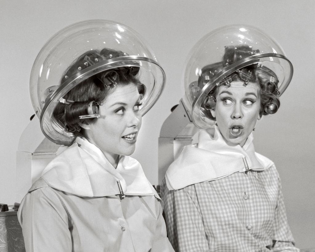 #11 Two women rollers curler in their hair sitting under hair salon dryers talking gossiping, 1960s