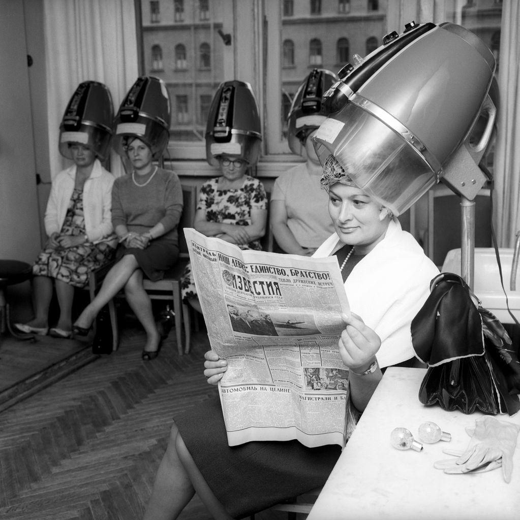 #17 Edda Vincenzi’s hair is being arranged before she comes on stage; she is reading a Russian newspaper. Moscow, September 1964.