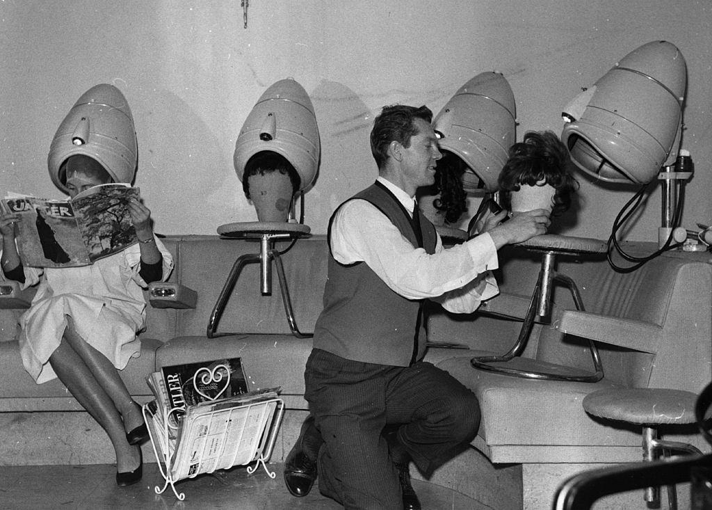 #42 A hairdresser drying wigs under the salon’s hairdryers.