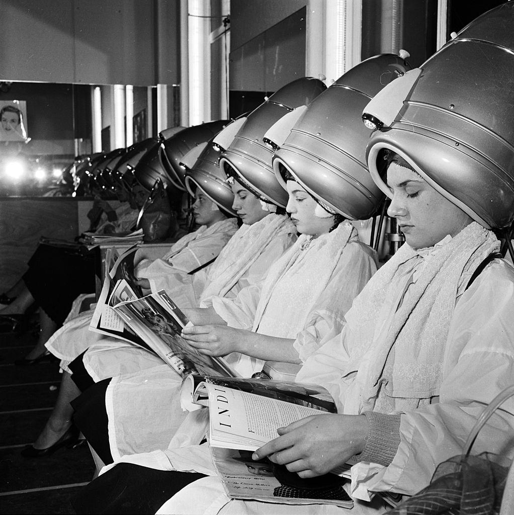 #47 Women relax underneath the hairdryers in a self-service hairdressing salon, 1956
