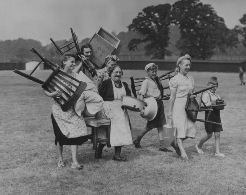 #1 Hop pickers move furniture into their summer quarters at Buston Manor near Maidstone, Kent, 1949.
