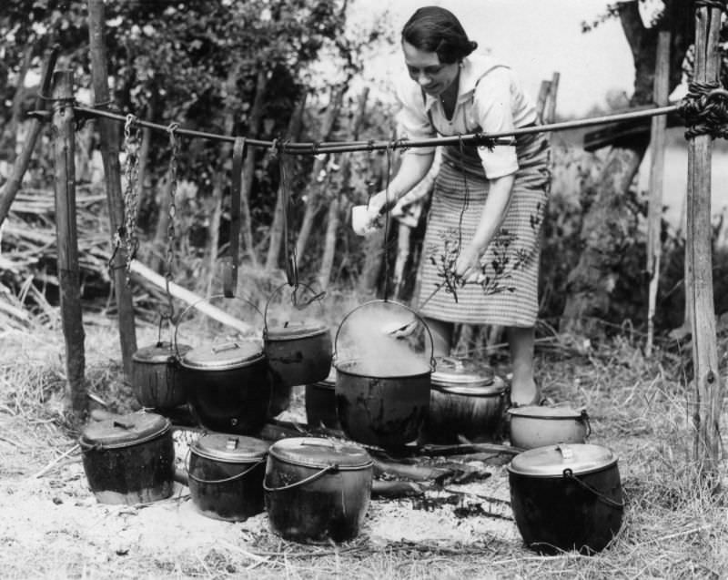 #17 A woman prepares a meal for hop pickers at the Whitbread hop camp in Paddock Wood, Kent, 1937.