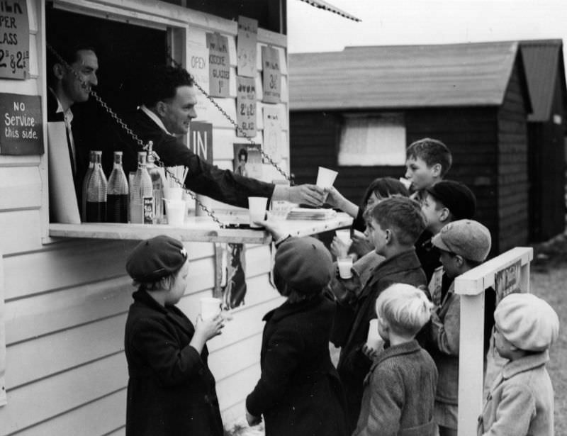 #18 A group of young hop pickers enjoy glasses of milk from a milk bar near the fields in Kent, 1938.