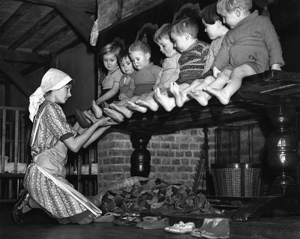 #21 A row of toddlers, evacuated from London during the Blitz, have their feet inspected at their new home in a 15th century mansion house in Kent.
