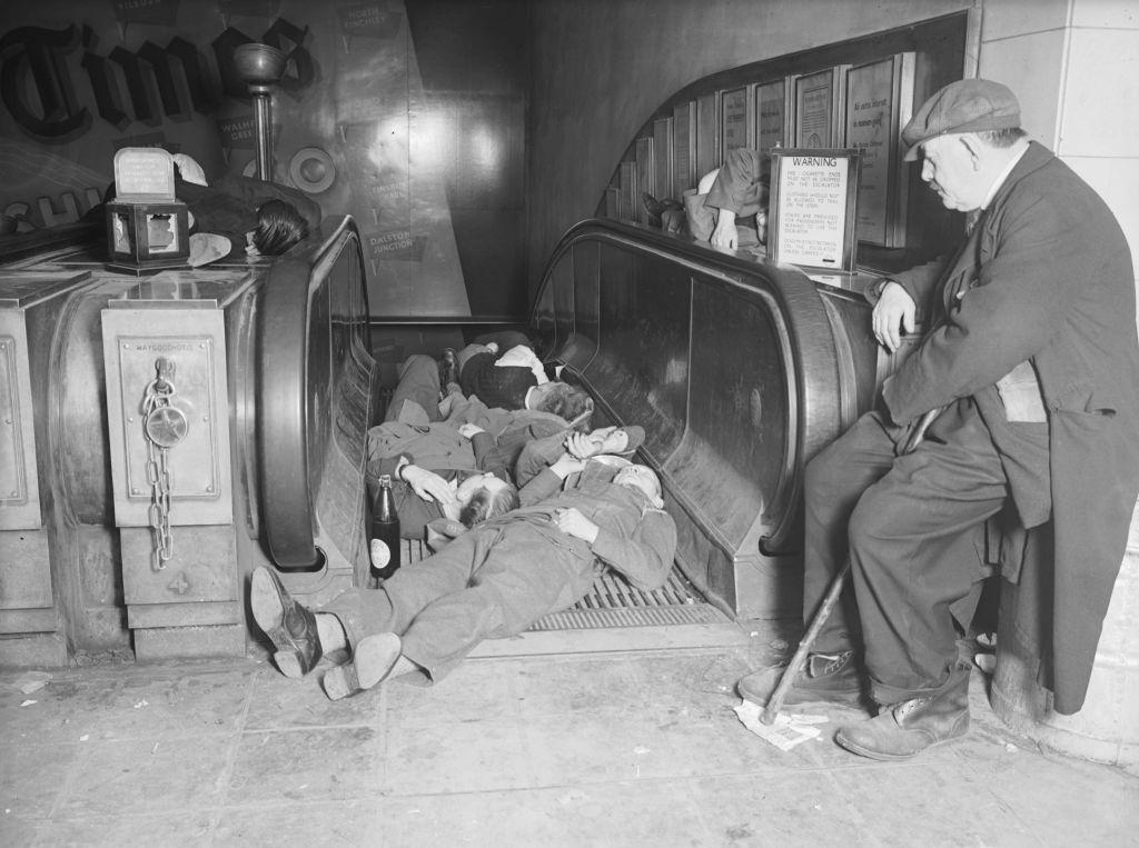 #10 A group of men sleeping on an escalator as they shelter from an air raid, in a London Underground Station during the Blitz, 1940.