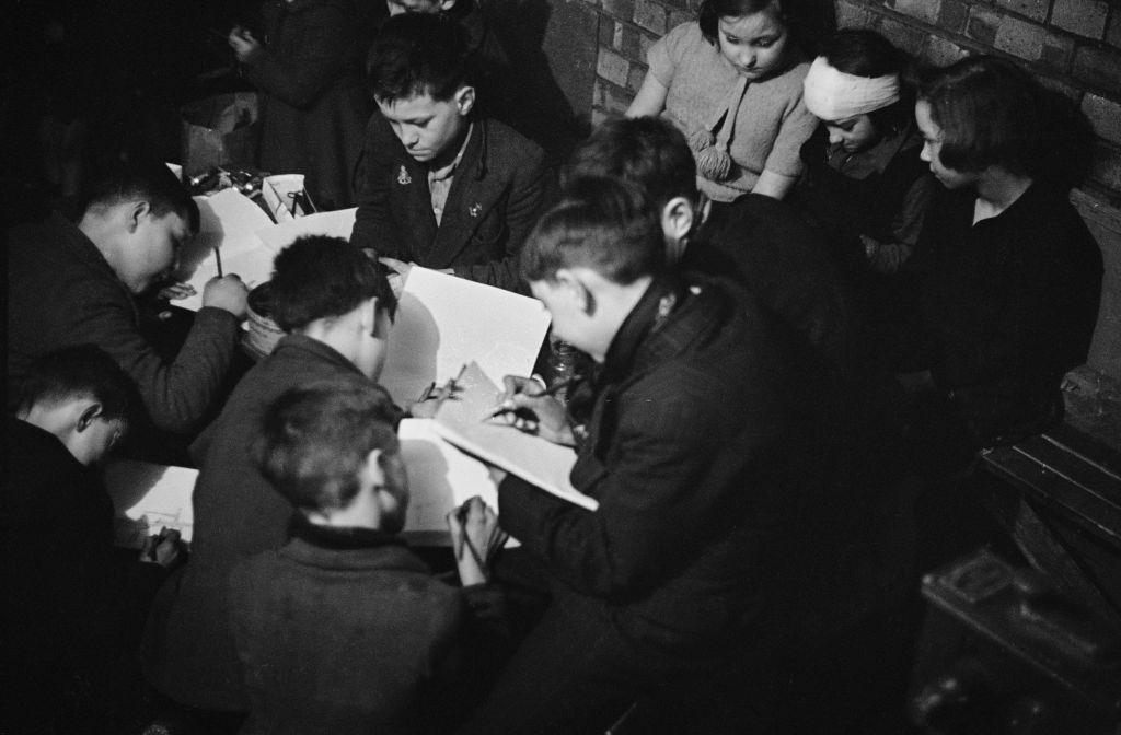 #15 Children drawing in an art class given by London County Council (LCC) teachers at an air raid shelter in Bermondsey, London during the Blitz, March 1941.