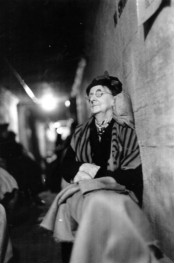 #35 An elderly lady propped up to sleep in an air raid shelter during the Blitz, London, October 1940.