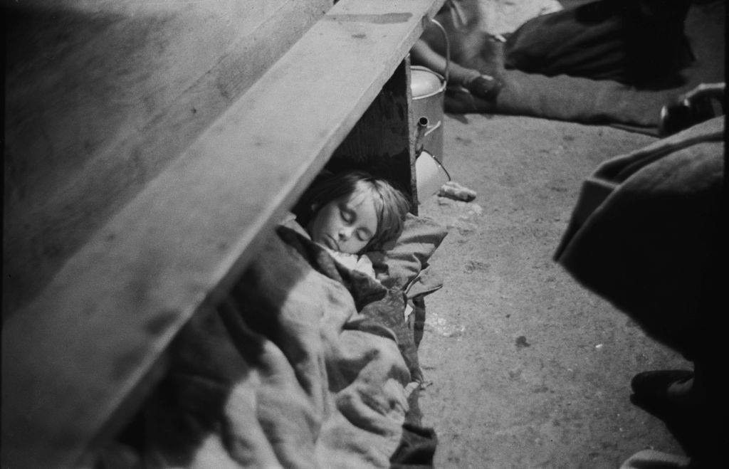 #37 A child sleeping in an air raid shelter during the Blitz, London, October 1940.