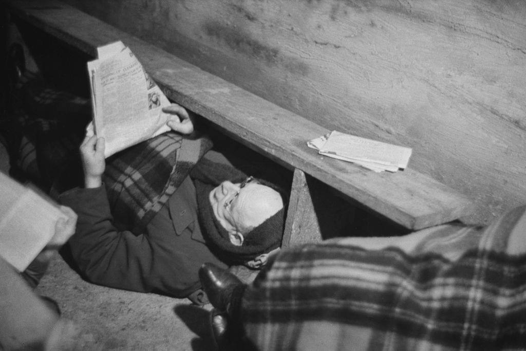 #39 A man reading a newspaper in an air raid shelter during the Blitz, London, October 1940.