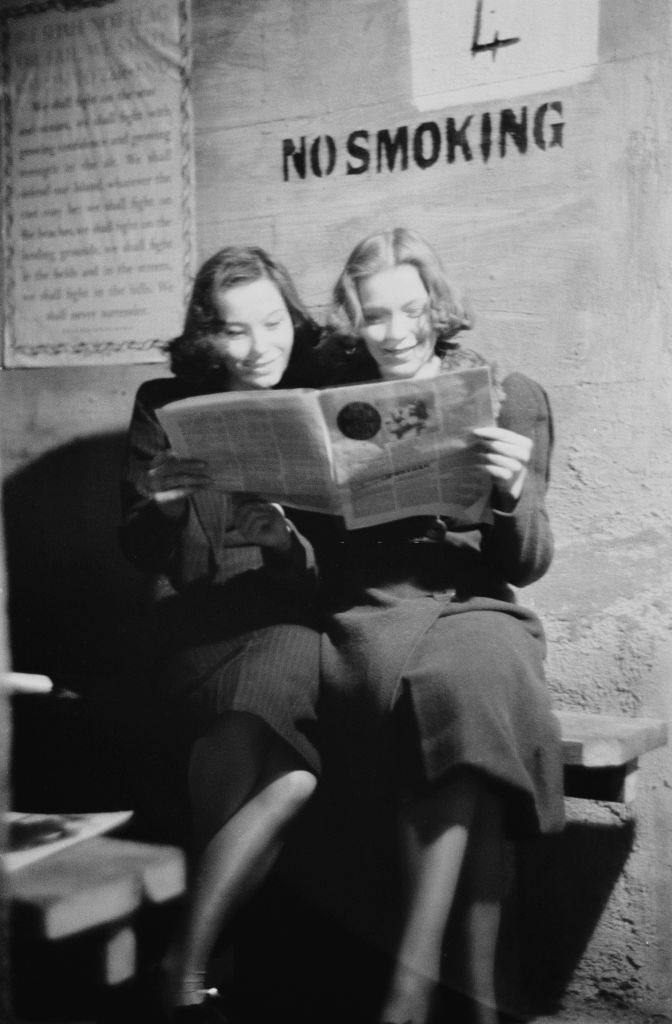 #45 Two young women reading a magazine in an air raid shelter during the Blitz, London, October 1940.