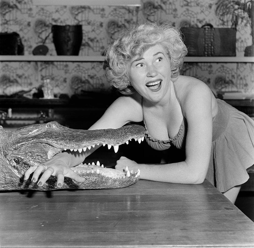 #10 A model poses with an alligator at the Los Angeles Alligator Farm, 1949