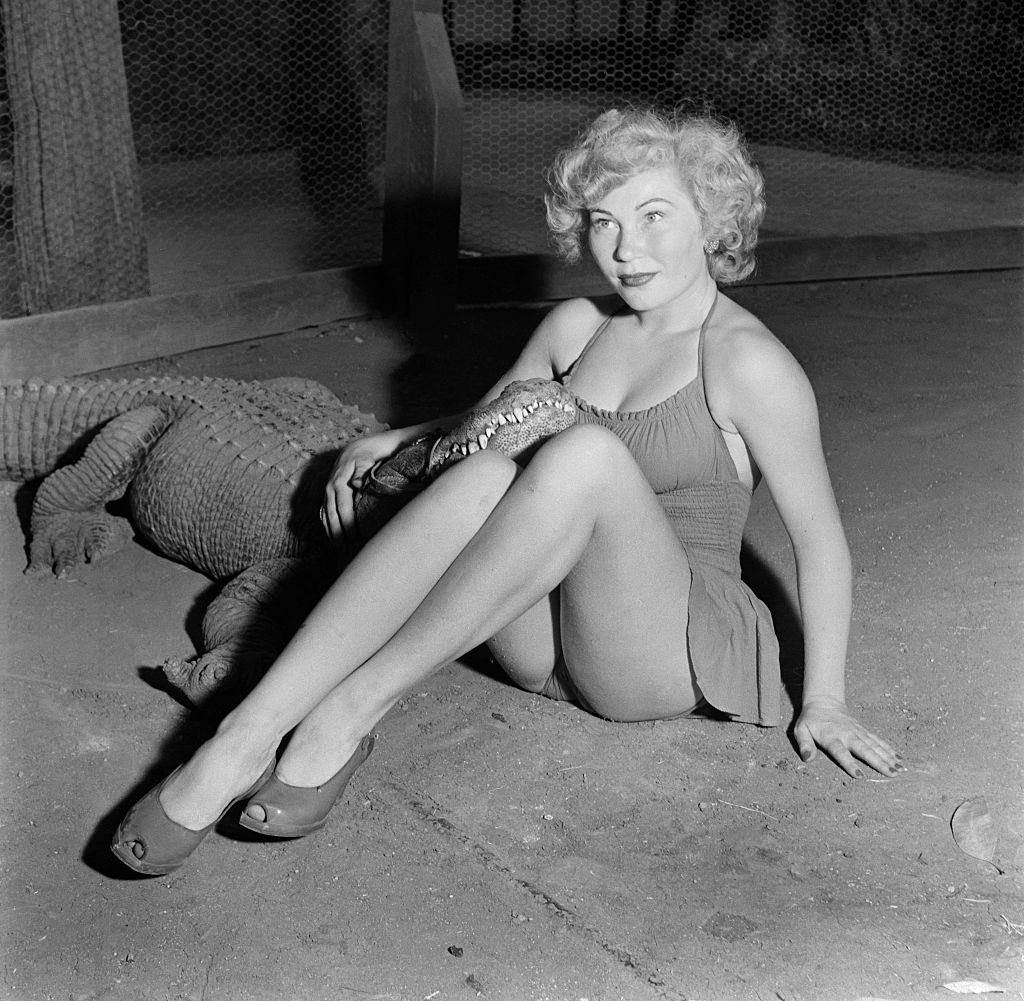 #13 A model poses with an alligator at the Los Angeles Alligator Farm, 1949