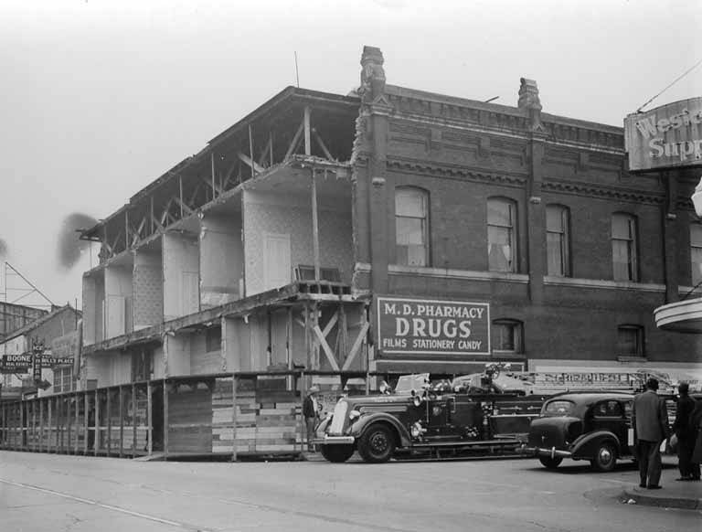 #13 Fire engine in front of damaged building with M. D. Pharmacy, Olympia, April 1949