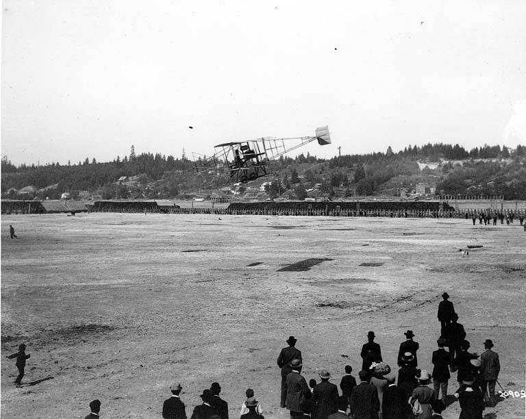 #14 Fred J. Wiseman piloting the first airplane (biplane) to land at the first air show (“flyer”) at Olympia, 1911.
