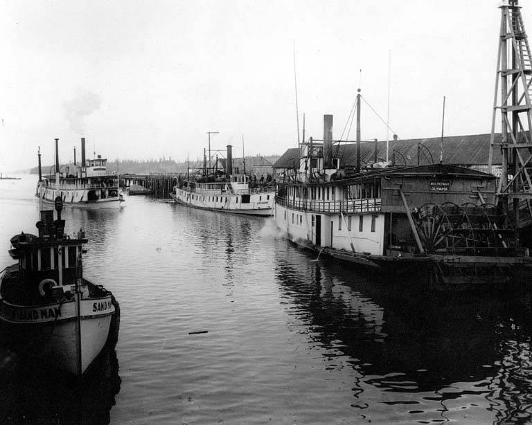 #17 Sternwheel steamers MULTNOMAH, GREYHOUND, and SIMPSON moored at dock in Olympia, with motor tug SAND MAN in foreground, 1911