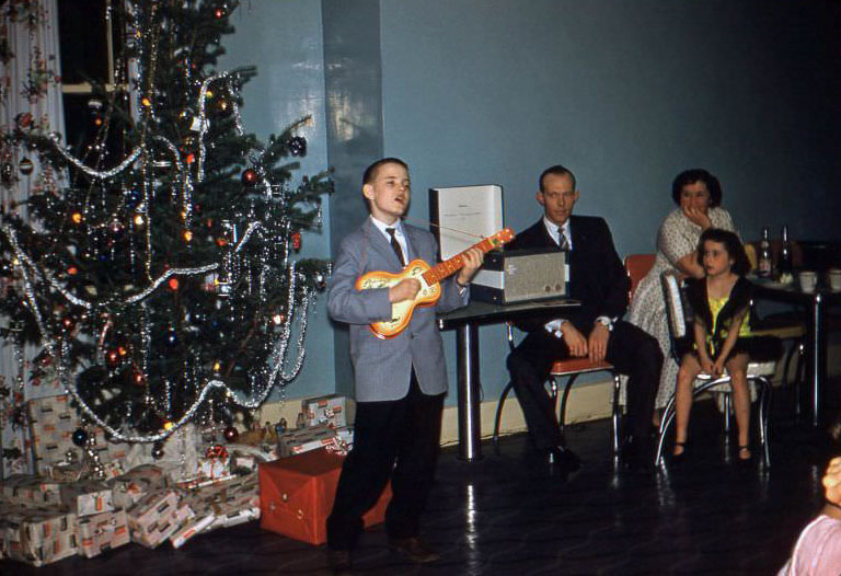 #38 Boy singing and playing guitar at Christmas, 1950s