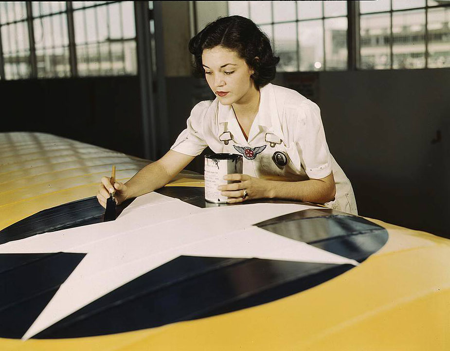 #96 Painting the American insignia on airplane wings is a job that Mrs. Irma Lee McElroy, a former office worker, does with precision and patriotic zeal, 1950s