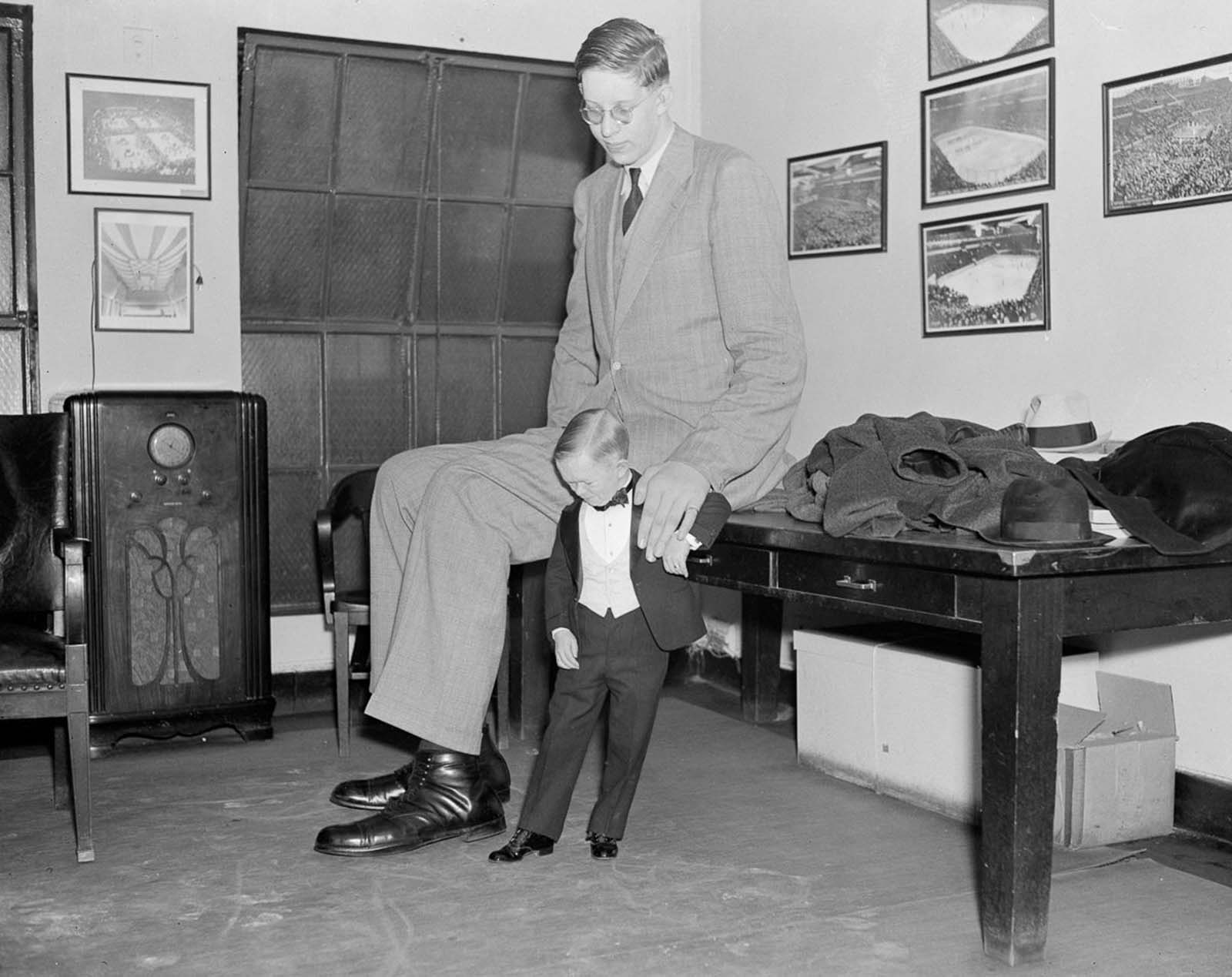 #19 “Major Mite” compares his size 4 shoes with Wadlow’s size 36, 1937.