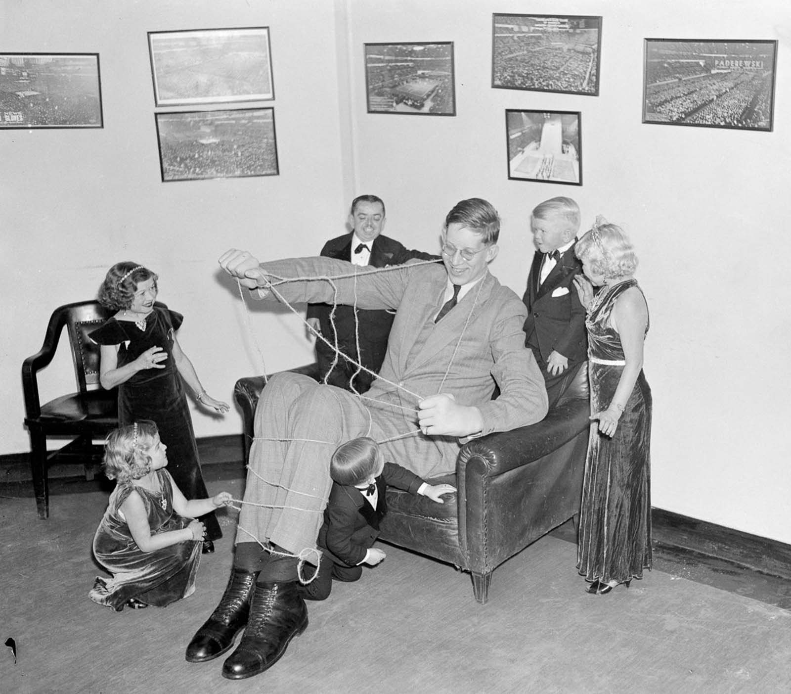 #20 In a nod to Gulliver’s Travels, performers from Ringling Brother’s Circus tie up Wadlow as a means of getting acquainted, 1937.