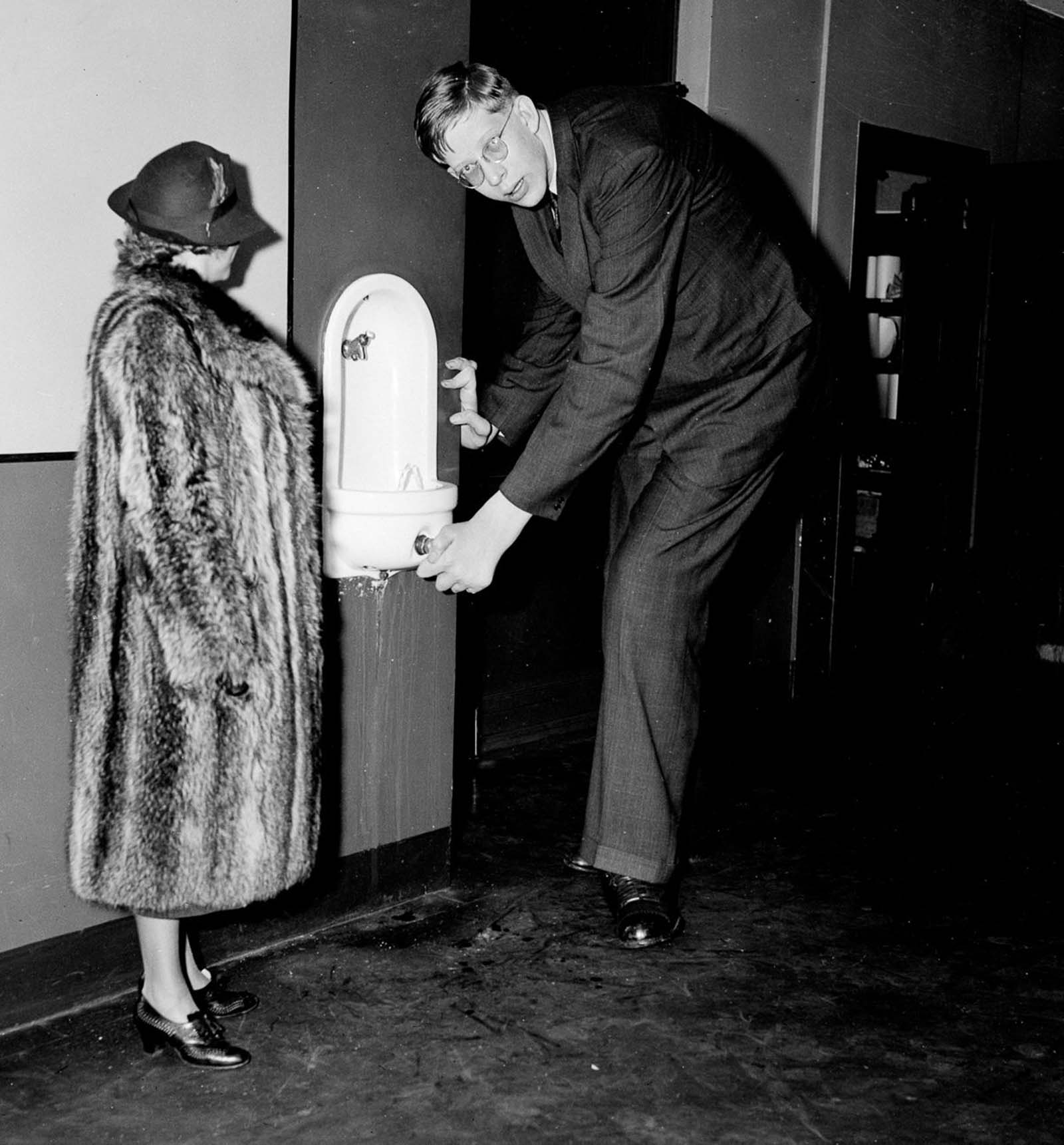 #24 Wadlow stoops for a drink during a visit to the Daily News offices in New York, 1937.