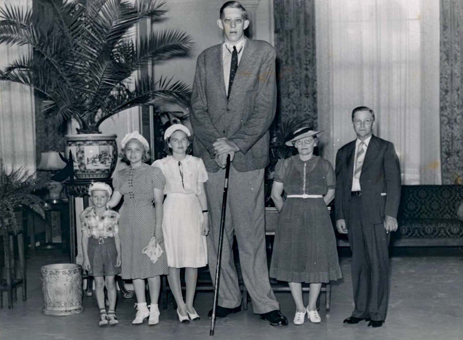 #28 The tallest man in the world stands alongside his family, who are all of average height and weight.