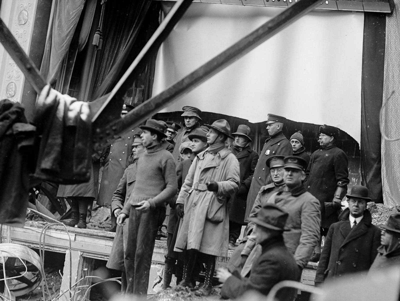 #13 Police, soldiers, and rescue workers examine the ruins of the Knickerbocker Theatre.