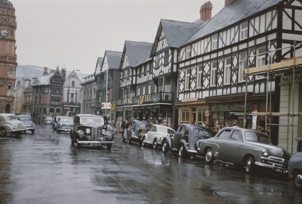 #91 Cars drive down the main street in the market town of Newtown in Montgomeryshire, Wales, 1960.
