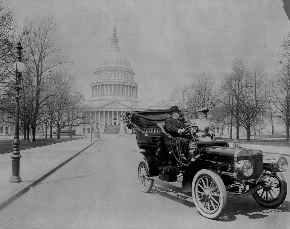 #72 Senator Benjamin Ryan Tillman seated in an automobile with a woman in front of the U.S. Capitol building.