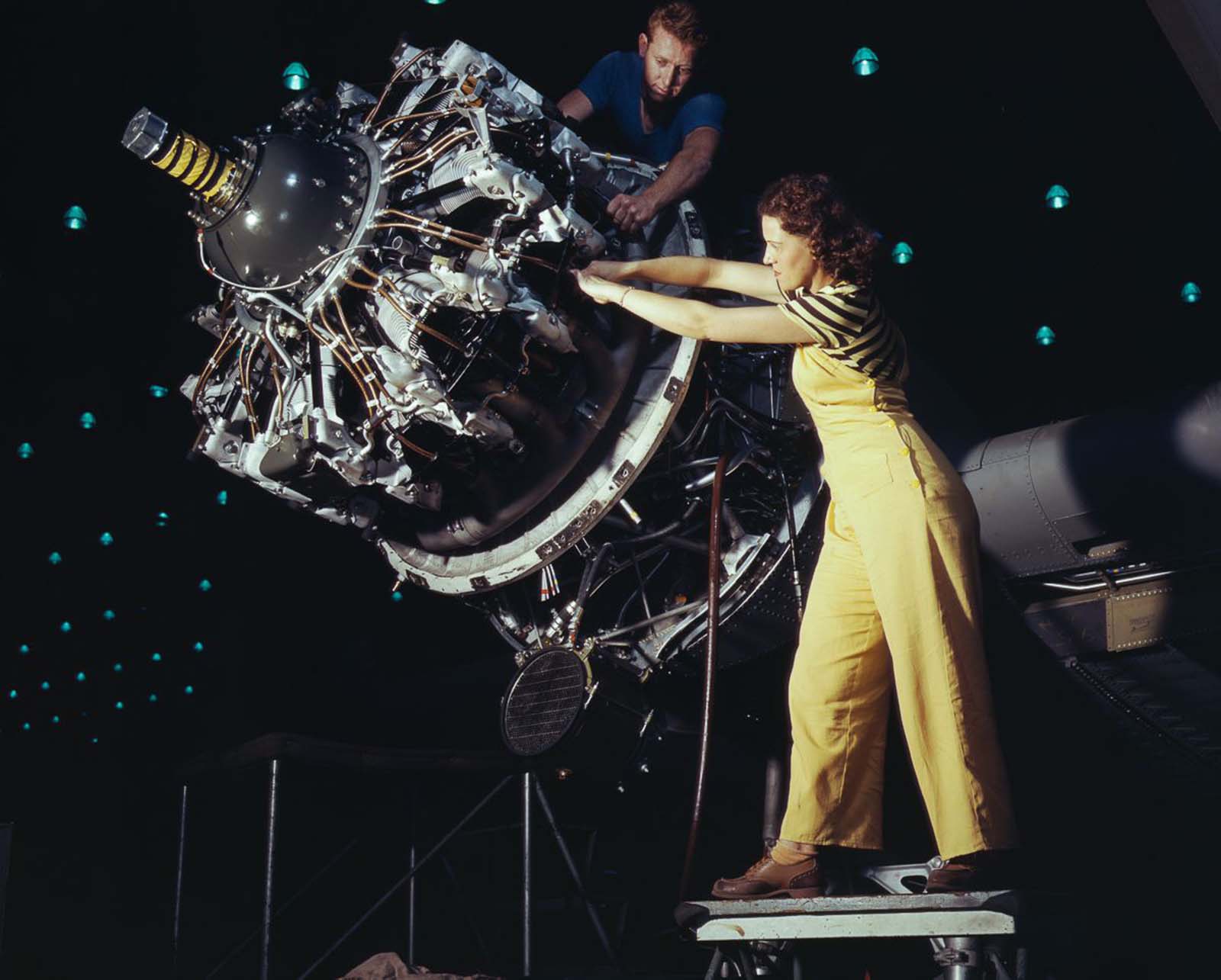 #16 Douglas Aircraft Company employees work an airplane motor at the plant in Long Beach, California, 1942.