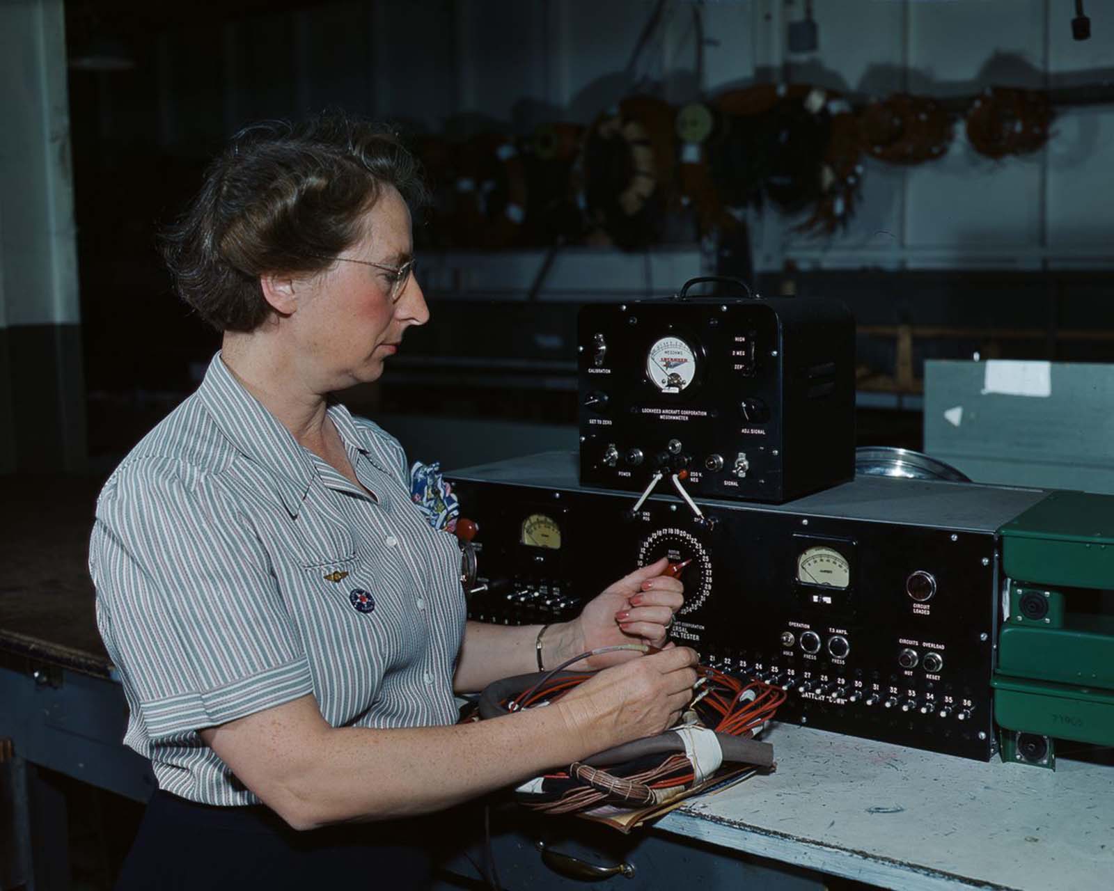 #17 An employee of Douglas Aircraft Company works with electrical wiring at the plant in Long Beach, California, 1942.