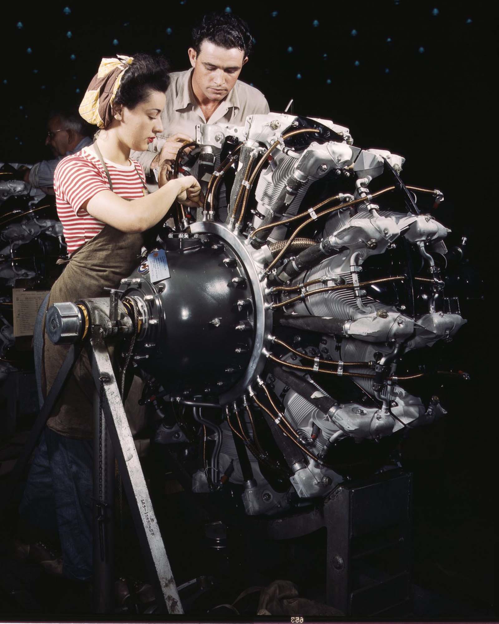 #19 Douglas Aircraft Company employees work on an airplane motor at the plant in Long Beach, California, 1942.