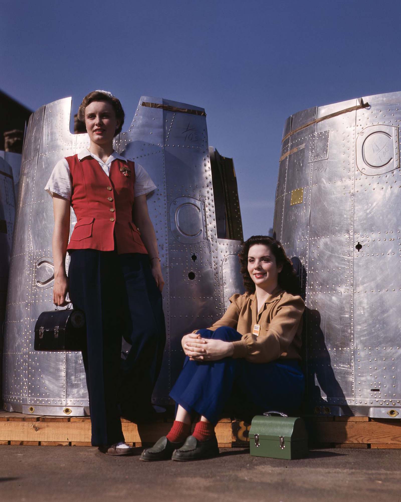 #20 Two assembly workers take a lunch break next to heavy bomber nacelle parts at the Douglas Aircraft Company plant in Long Beach, California, 1942.