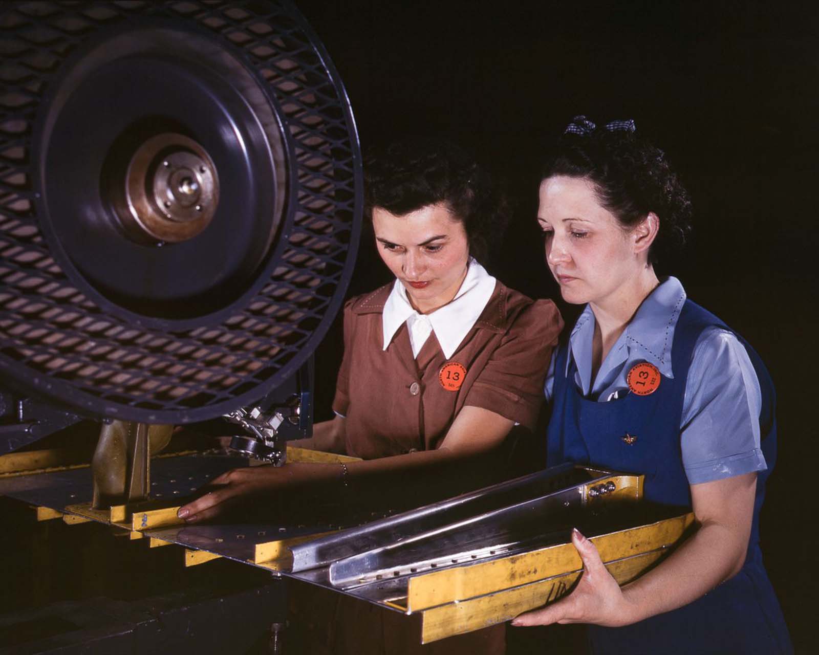 #25 Workers punch rivet holes in a frame member for a B-25 bomber at the North American Aviation plant in Inglewood, California, 1942.
