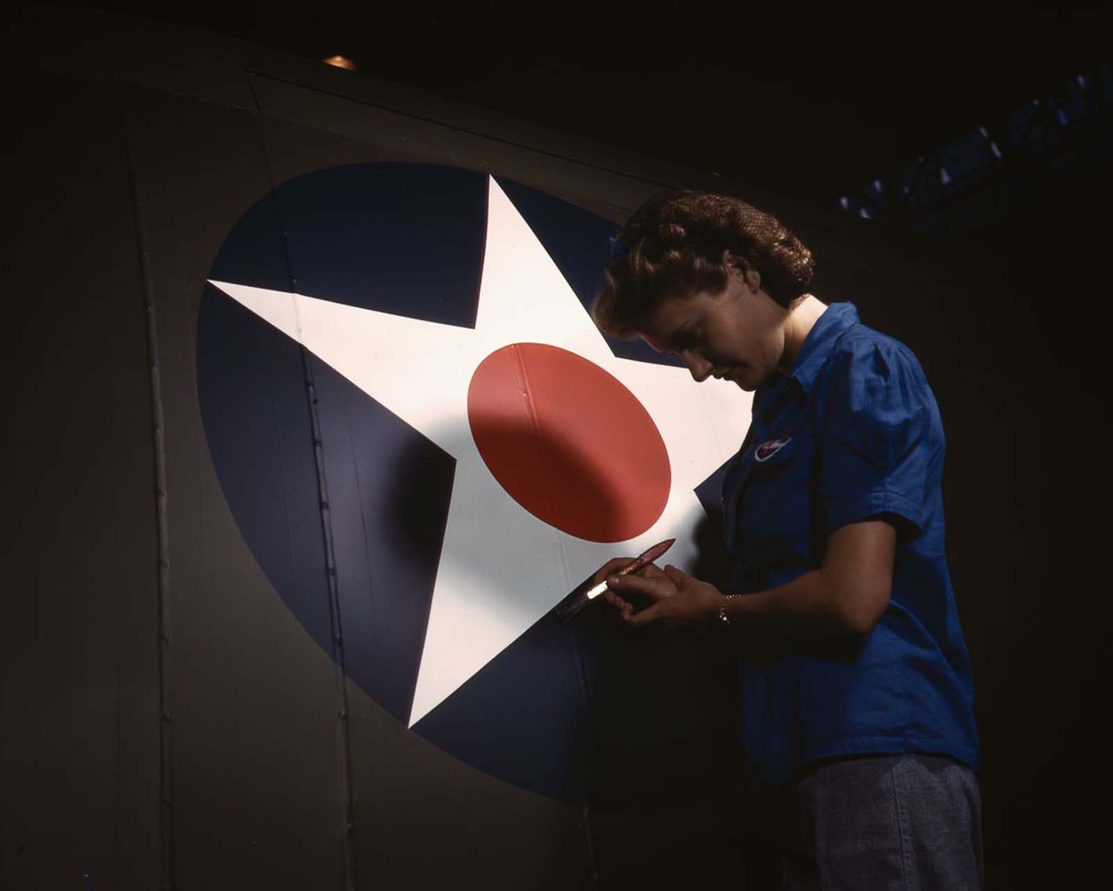 #31 A Vultee Aircraft employee touches up the U.S. Army Air Forces insignia on the fuselage of a “Vengeance” dive bomber at the plant in Nashville, Tennessee, 1943.